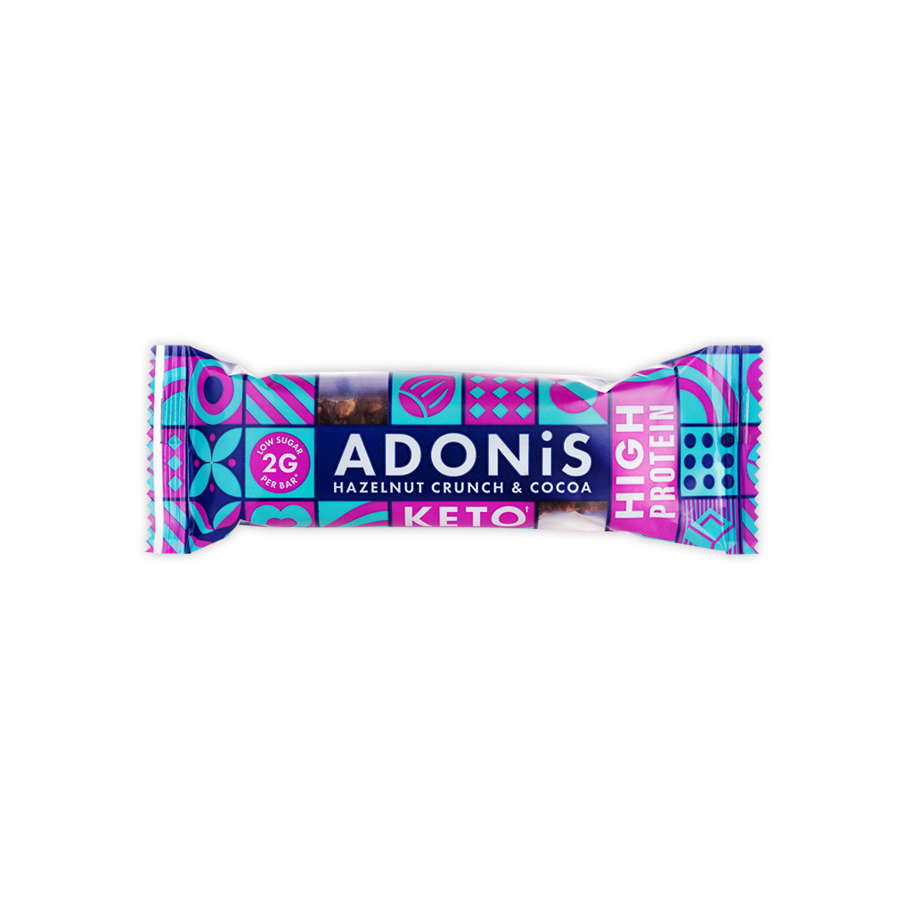 Keto baton z chrupiących orzechów laskowych i czekolady z firmy ADONIS. W niebiesko-fioletowym opakowaniu znajduje się 35g keto batonik.
